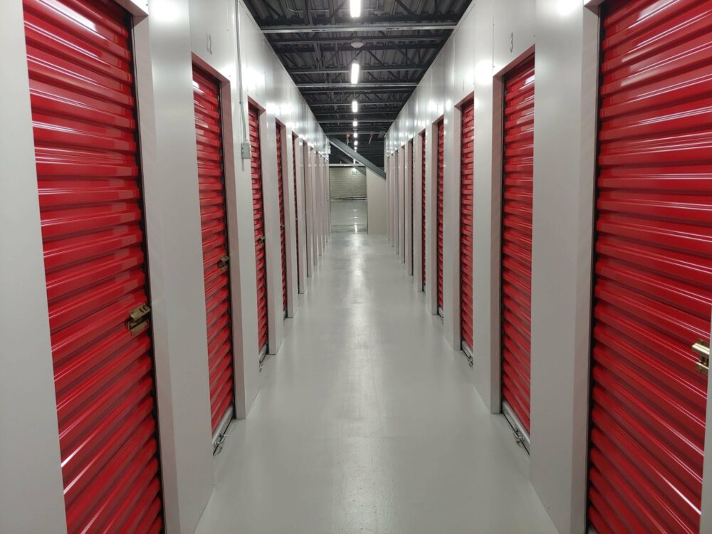 A hallway with self storage units that have red doors